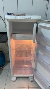 an empty refrigerator with its door open in a kitchen at Apartamento 3 Aconchegante São Jorge in Manaus