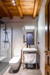 a bathroom with a toilet and a sink and a mirror at Place of charm and tranquility in Ordino