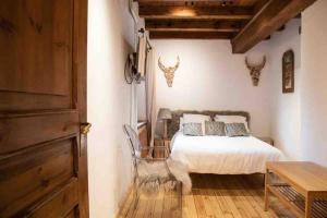a bedroom with a bed and a table and a chair at Place of charm and tranquility in Ordino