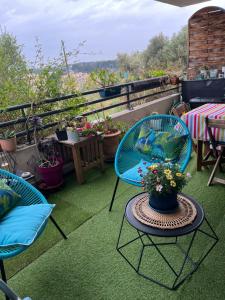 a balcony with two chairs and a table with flowers at Charme et calme in Marseille