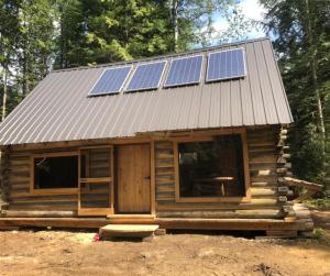 a cabin with solar panels on top of it at Mini Moo-light Cabin in Clearwater