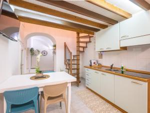a kitchen with white cabinets and blue chairs at CASA IRYNA in Pietra Ligure