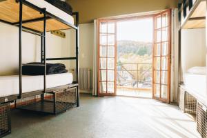 a room with two bunk beds and a large window at Bike Hostel in San Martín de los Andes