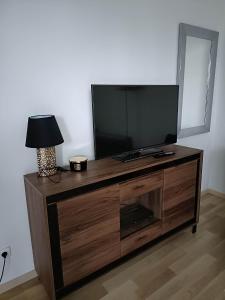 a flat screen tv sitting on top of a wooden entertainment center at Apartament Paderewskiego 1 in Zielonka