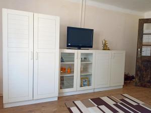 a white cabinet with a television on top of it at Két Kerék Vendégház in Patvarc