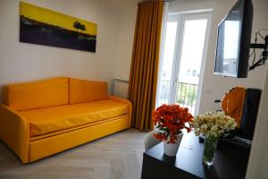 龐貝的住宿－Palazzo Archeo，客厅配有橙色沙发和桌子