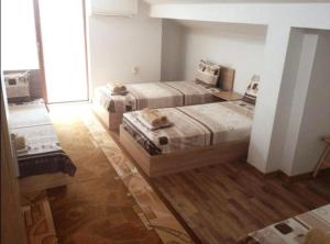 two beds in a room with wooden floors at Роден Край Homeland in Sopot