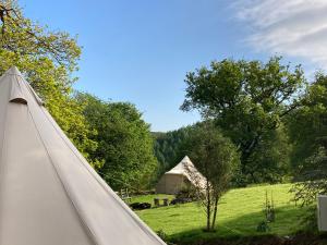 uma tenda de lona num campo com árvores e um campo em Remote Cabin & 3 Giant Tents Retreat em Abergele