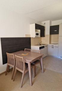 a kitchen with a wooden table and two chairs at Home sweet Valberg in Péone