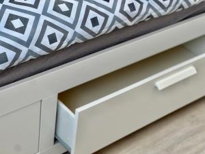 a drawer in a white bed with a black and white pillow at Nujen- Hotel und Apartment Stuttgart Zuffenhausen in Stuttgart