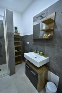 uma casa de banho com um lavatório, um WC e um espelho. em Via Cino Cagliari em Cagliari