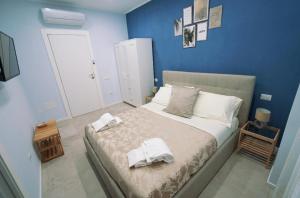 - une chambre avec un lit et des serviettes dans l'établissement Via Cino Cagliari, à Cagliari