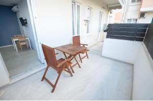 2 cadeiras e uma mesa de madeira numa varanda em Via Cino Cagliari em Cagliari