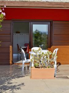 een patio met een tafel en stoelen voor een gebouw bij GF Apartments La Vigna in Badesi