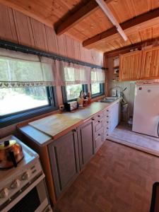 - une cuisine avec des placards en bois et un réfrigérateur blanc dans l'établissement Forest Cottage, à Fluberg