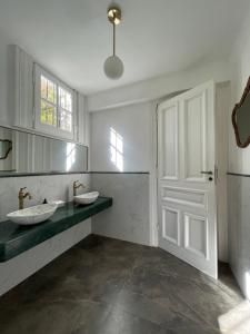 a bathroom with two sinks and a white door at Casa Villa Julia in Tigre