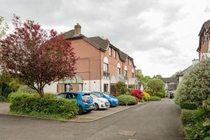 a row of cars parked in front of a house at Templepatrick family home beside the Rabbit hotel in Templepatrick