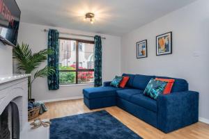 a living room with a blue couch and a fireplace at Templepatrick family home beside the Rabbit hotel in Templepatrick