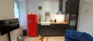 cocina con nevera roja junto a una mesa en Studio atypique dans bel immeuble de 1820, en Fumel