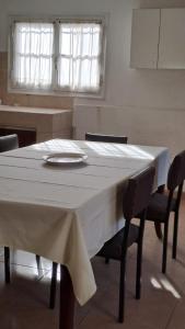 una mesa de comedor con un mantel blanco. en Casa Tiburcio en Godoy Cruz