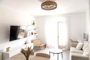 a white living room with a couch and a table at Apartamento con Parking a 50m de la playa in Sant Antoni de Calonge