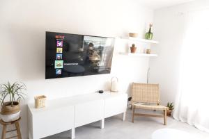 a living room with a tv on a wall at Apartamento con Parking a 50m de la playa in Sant Antoni de Calonge