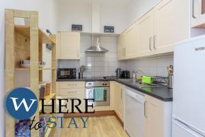 a kitchen with white cabinets and white appliances at Beautiful 2Bed Ground-F Pitt St. Apartment in Edinburgh