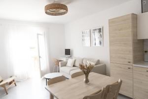 un soggiorno con tavolo e divano di Apartamento con Parking a 50m de la playa a Sant Antoni de Calonge