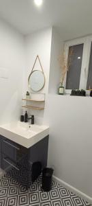 a white bathroom with a sink and a mirror at Studio atypique dans bel immeuble de 1820 in Fumel