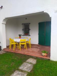 una mesa amarilla y sillas en un patio en stella marina en Porto Recanati