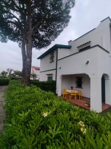 un edificio bianco con un tavolo e un albero di stella marina a Porto Recanati