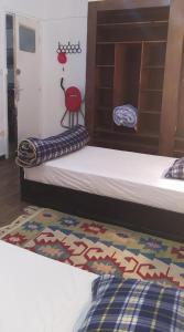 Cette chambre comprend 2 lits et un tapis. dans l'établissement Chambre du jardin, à Rabat