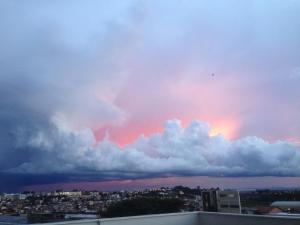 a cloudy sky with a bird flying in the sky at Aconchego bem localizado in Varginha