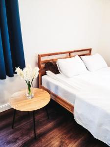 un dormitorio con 2 camas y una mesa con un jarrón de flores en Orłowski Bluszcz, en Gdynia
