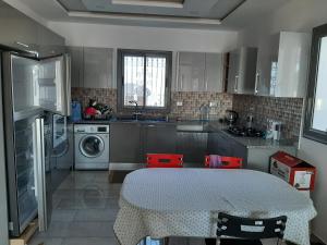 uma cozinha com uma mesa e uma máquina de lavar roupa em Villa de charme em Mezraya