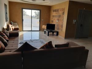 a living room with two couches and a television at Villa de charme in Mezraya