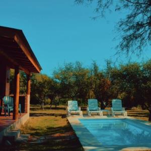 een zwembad met stoelen en een prieel bij Cabaña Flor de Lis in San Javier