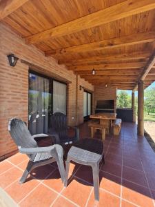a patio with chairs and a table and a piano at Cabaña Flor de Lis in San Javier