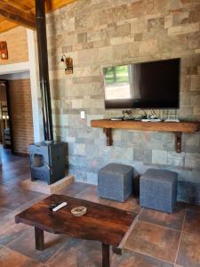 een woonkamer met een tv en een houtkachel bij Cabaña Flor de Lis in San Javier