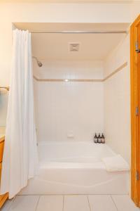 een badkamer met een wit bad en een douche bij Targhee Rentals 122 in Driggs Idaho near Grand Targhee Ski Resort King Size Bed in Driggs