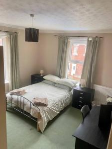 a bedroom with a large bed and a window at Family Home Near City Centre in Carlisle