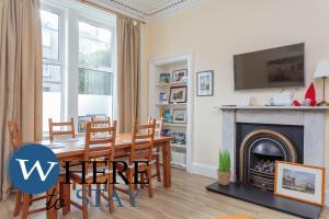 a dining room with a table and a fireplace at Beautiful 2Bed Ground-F Pitt St. Apartment in Edinburgh