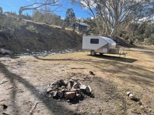 a white trailer parked next to a pile of rocks at Jindabyne caravan hire in Jindabyne