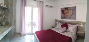 a bedroom with a bed with pink and white pillows at Luxurious Maisonettes Nina & Tomas in Sivota in Sivota