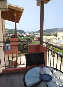 a balcony with a glass table and a chair at Luxurious Maisonettes Nina & Tomas in Sivota in Sivota