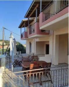 a balcony of a house with a table and chairs at Luxurious Maisonettes Nina & Tomas in Sivota in Sivota