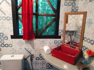 Promoção Semana Santa em Santo André - Casa da Floresta في سانت أندري: حمام مع حوض احمر ومرآة