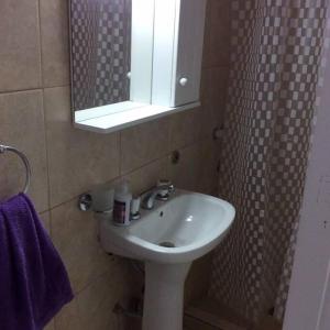 y baño con lavabo y espejo. en Pellegrini Departamentos muy confortable y bien ubicado en Godoy Cruz