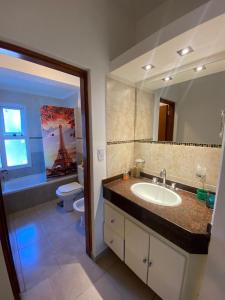 a bathroom with a sink and a toilet and a mirror at Alojamiento Necochea in La Banda