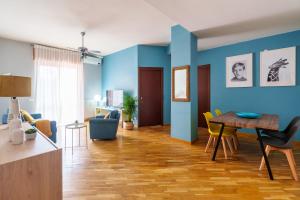 een woonkamer met blauwe muren en een tafel en stoelen bij [Casa Graziola] Wi-Fi, Netflix, 5* Comfort in Gaggiano
